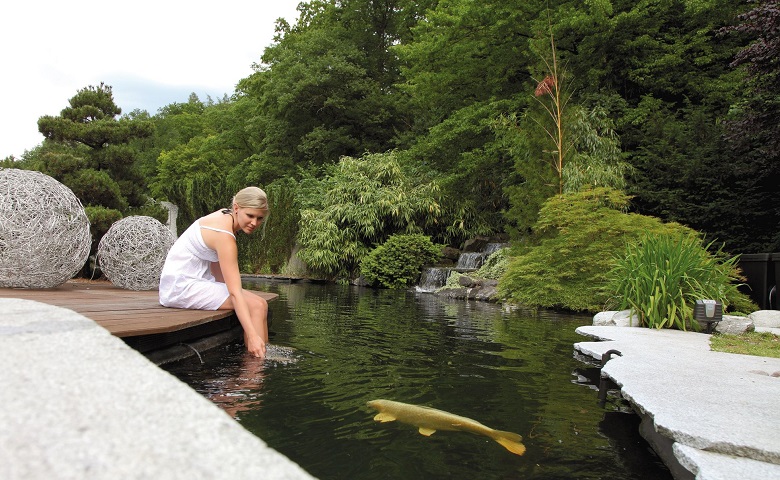 lady sitting by the koi fish pond