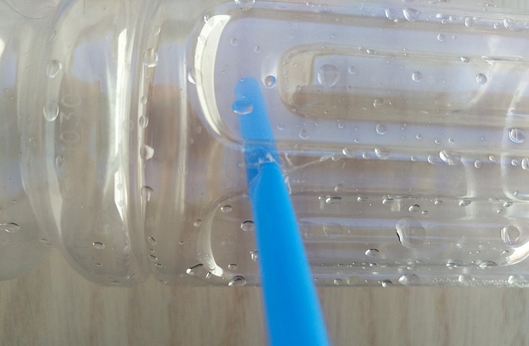 inserting straw in bottle